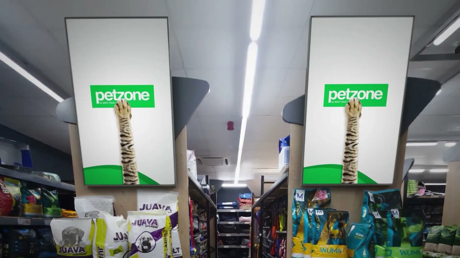 Two tall digital screens inside a Petzone store