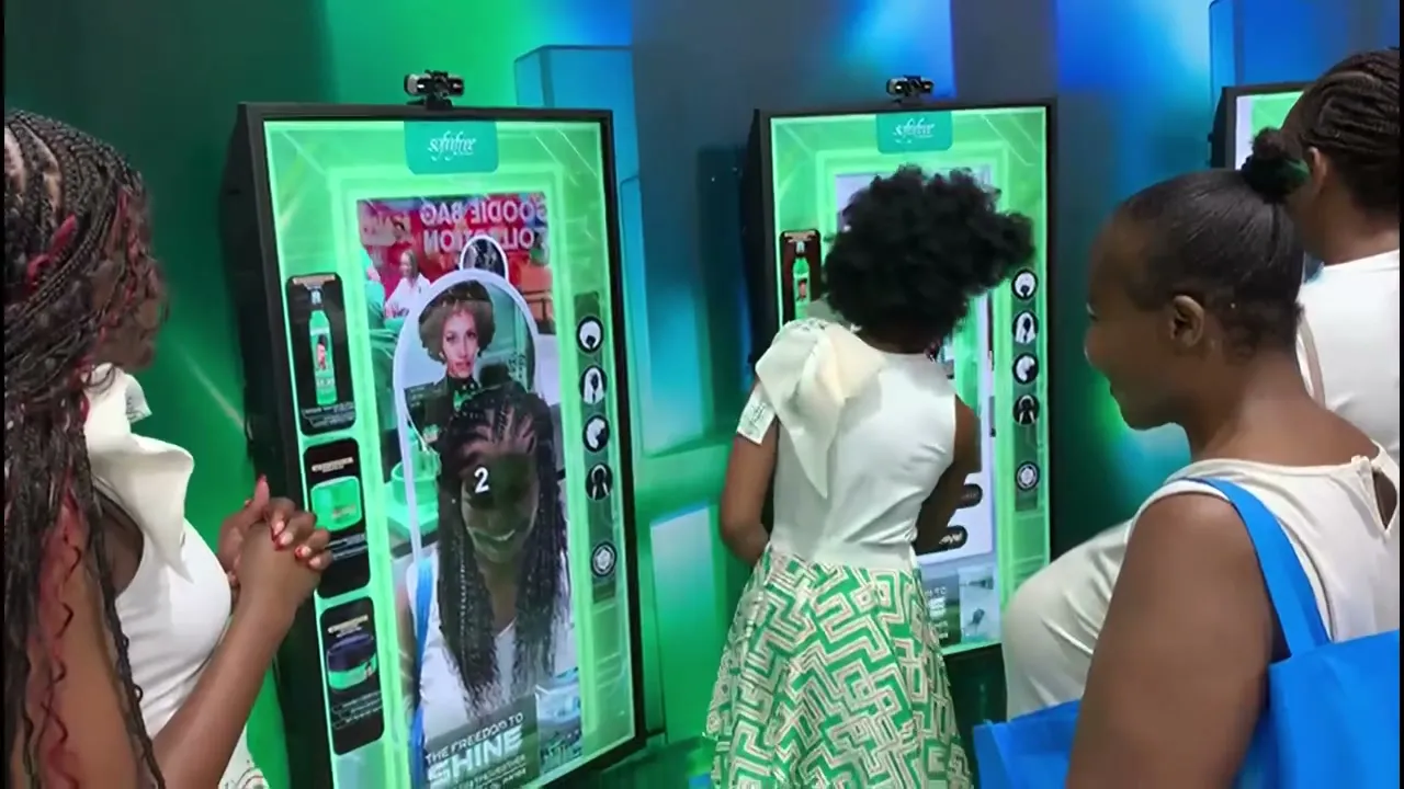 Shoppers trying styles on the Sofnfree Magic Mirror