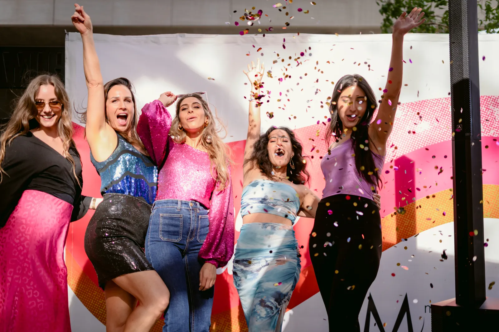 Magos team members dancing under confetti at a seventies-themed party
