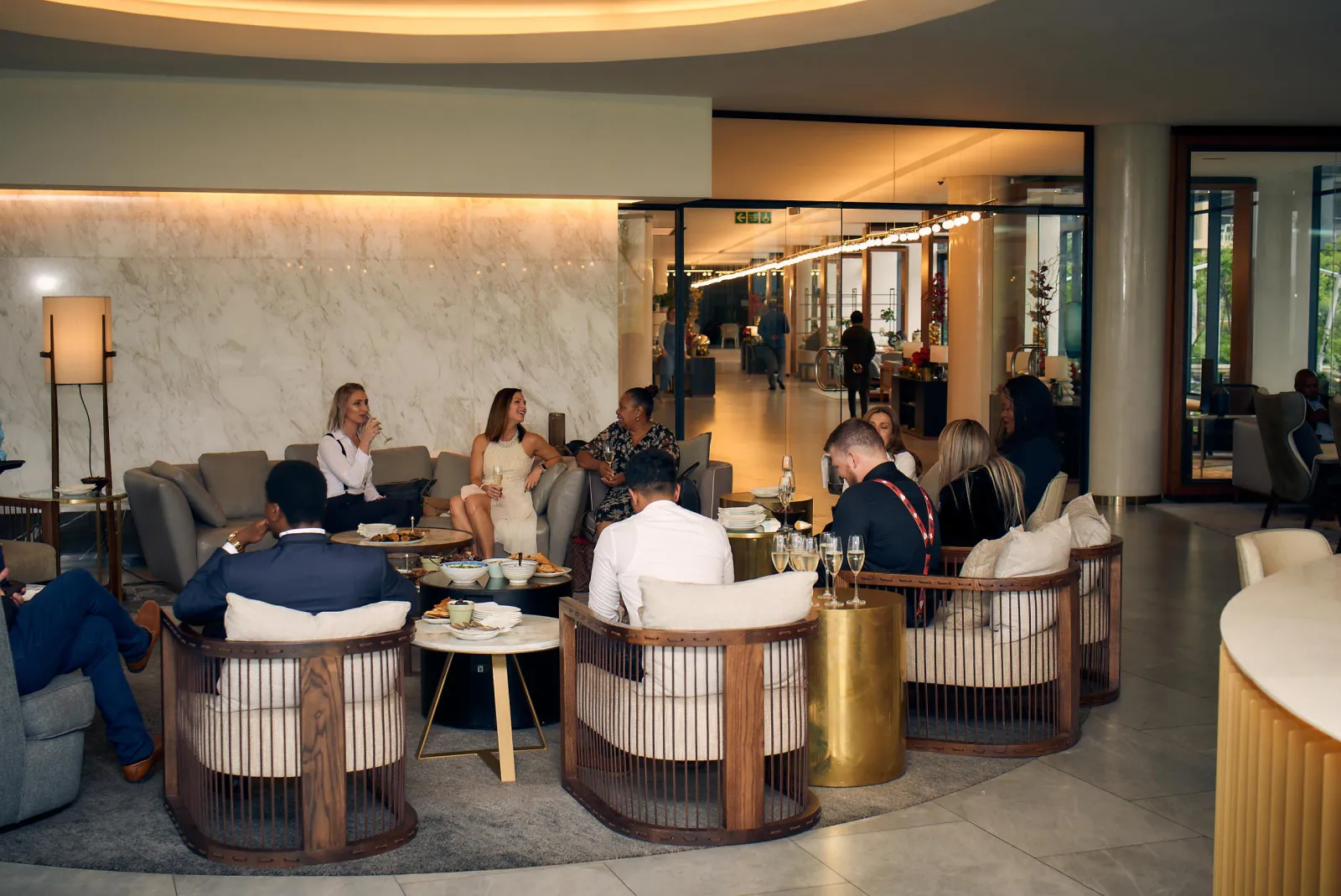 Guests seated in a hotel lounge in the evening
